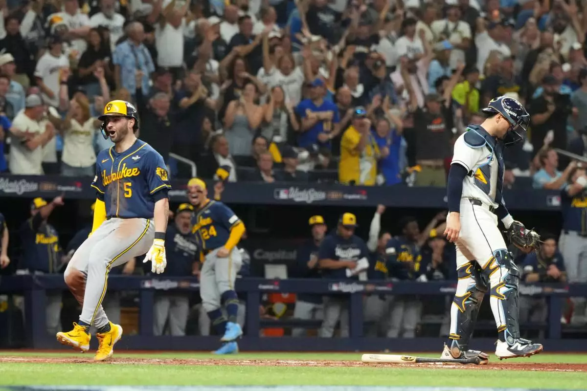 Milwaukee Brewers' Garrett Mitchell celebrates past Tampa Bay Rays catcher Nick Fortes after scoring during the fifth inning of Game 3 of baseball's World Series, Monday, Oct. 26, 2026, in St. Petersburg, Fla., between the Milwaukee Brewers and the Tampa Bay Rays. (AP Photo/Ashley Landis)