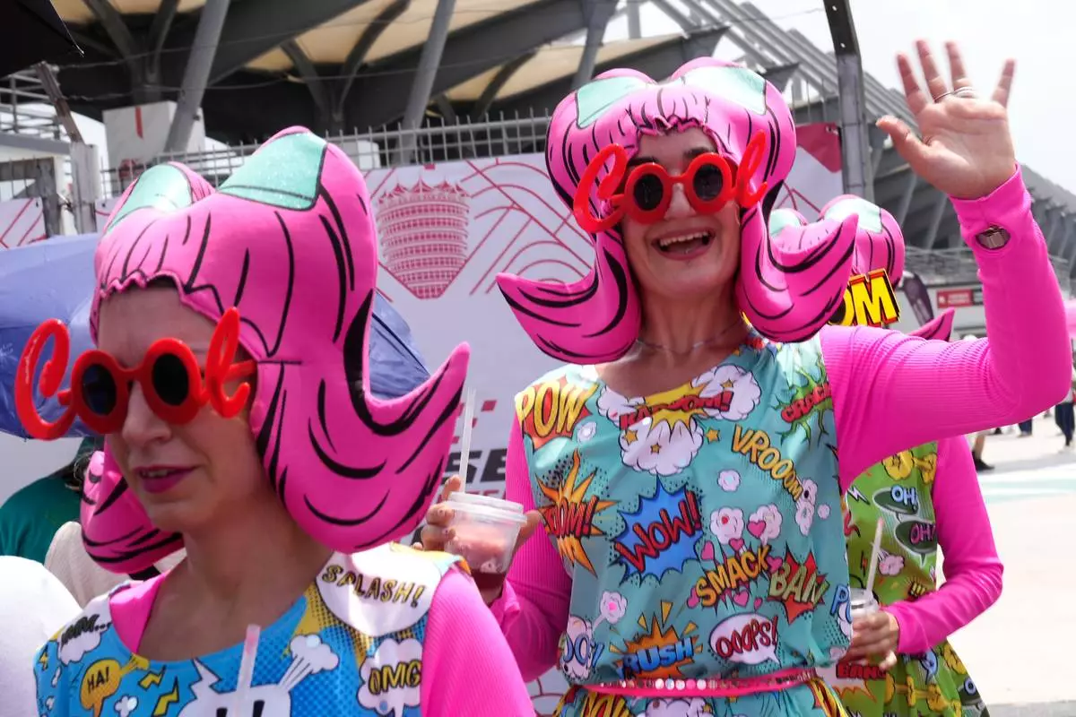 Artists wearing costumes arrive to perform for fans ahead of the first free practice of the Bahrain Grand Prix in Sepang, Malaysia, Friday, Oct. 2, 2026. (AP Photo/Aijaz Rahi)