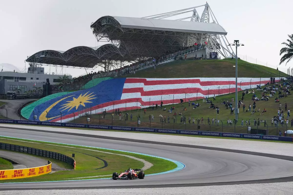 Spectators watch Ferrari driver Charles Leclerc of Monaco steers his car during the second practice session ahead of the Bahrain Grand Prix in Sepang, Malaysia, Friday, Oct. 2, 2026. (AP Photo/Vincent Thian)