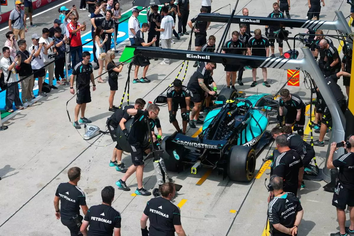 People watch Mercedes pit crew practice on the car of driver Andrea Kimi Antonelli of Italy ahead of the first free practice session of the Bahrain Grand Prix in Sepang, Malaysia, Friday, Oct. 2, 2026. (AP Photo/Vincent Thian)