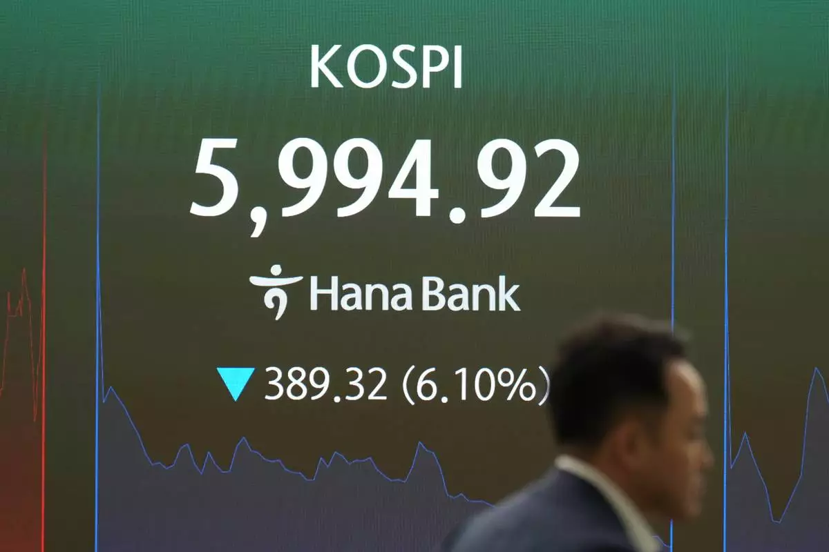 A dealer walks past the screen showing the Korea Composite Stock Price Index (KOSPI) at a dealing room of Hana Bank in Seoul, South Korea, Tuesday, Oct. 13, 2026. (AP Photo/Lee Jin-man)
