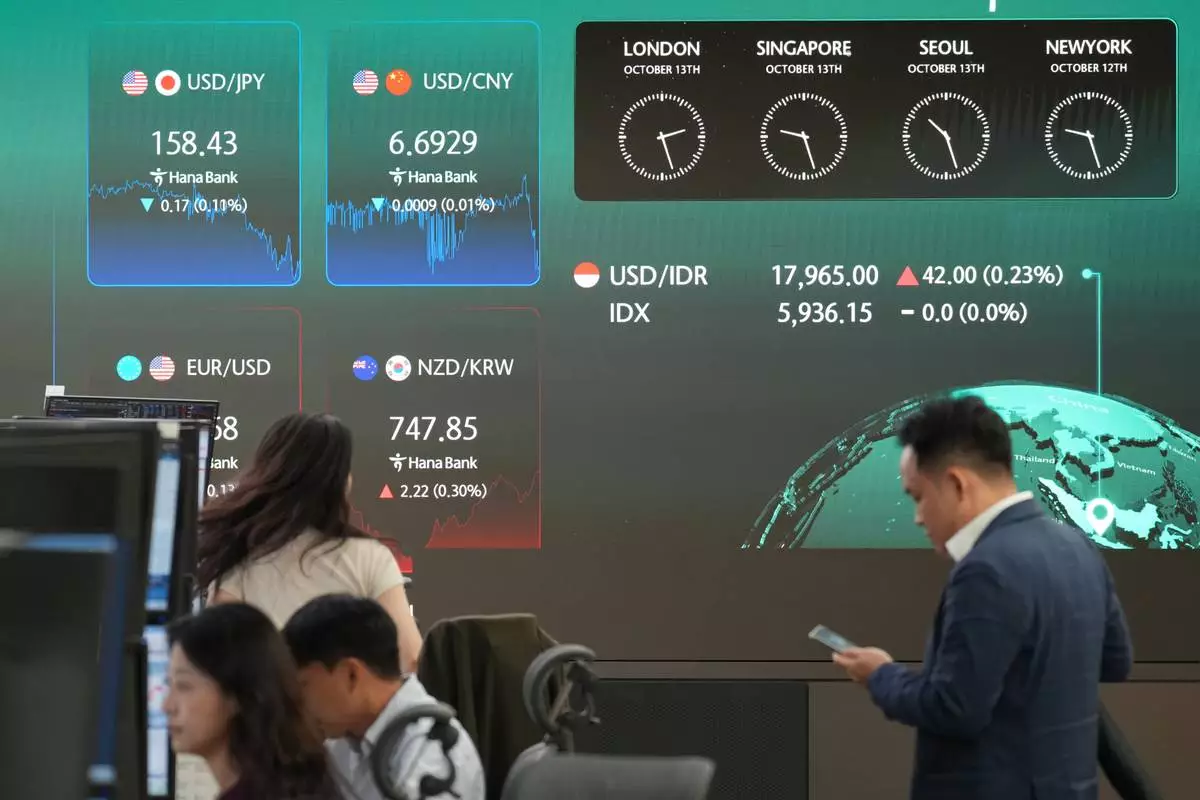 Dealers work near the screens showing the foreign exchange rates at a dealing room of Hana Bank in Seoul, South Korea, Tuesday, Oct. 13, 2026. (AP Photo/Lee Jin-man)