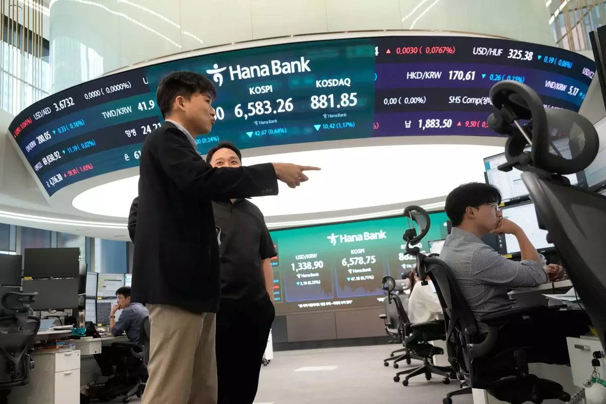 Currency traders work at the foreign exchange dealing room of the Hana Bank headquarters in Seoul, South Korea, Monday, Oct. 12, 2026. (AP Photo/Ahn Young-joon)