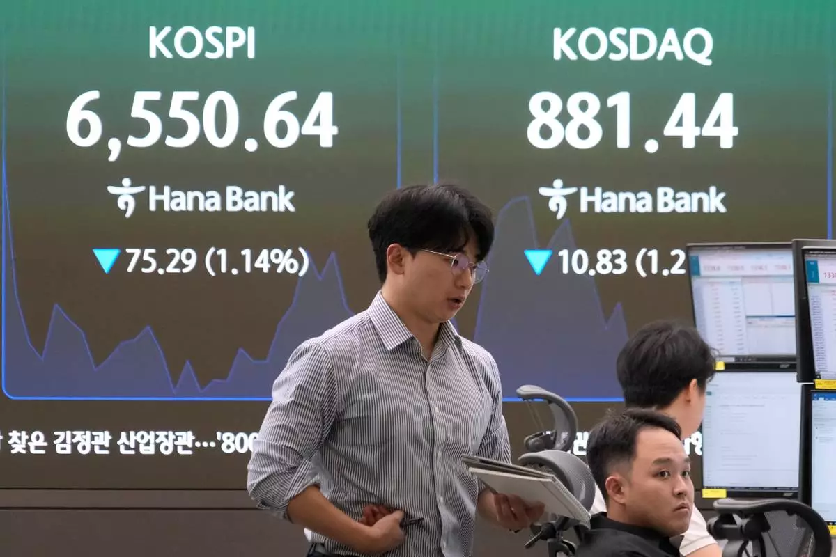 Currency traders work near a screen showing the Korea Composite Stock Price Index (KOSPI) at the foreign exchange dealing room of the Hana Bank headquarters in Seoul, South Korea, Monday, Oct. 12, 2026. (AP Photo/Ahn Young-joon)