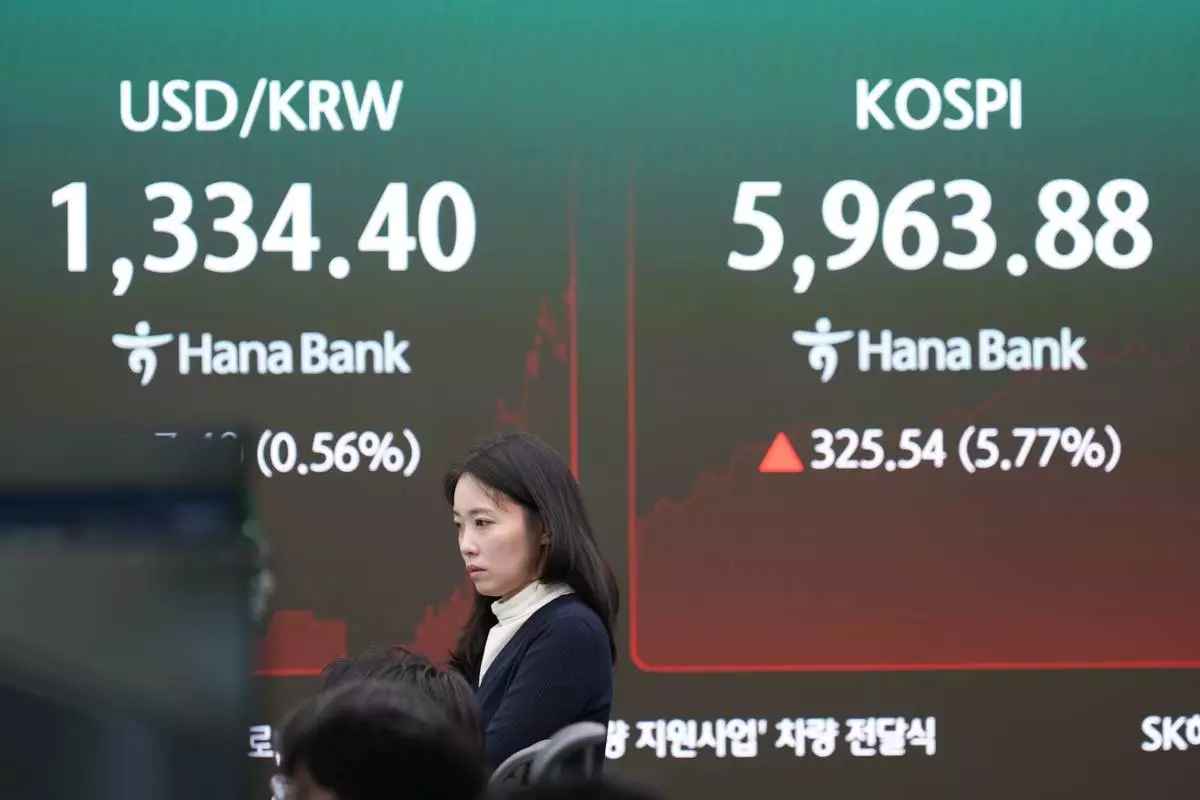 A dealer stands near the screens showing the Korea Composite Stock Price Index (KOSPI) and the foreign exchange rate between the U.S. dollar and the South Korean won in a dealing room of Hana Bank in Seoul, South Korea, Wednesday, Oct. 28, 2026. (AP Photo/Lee Jin-man)