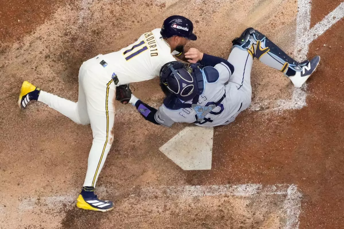 Milwaukee Brewers' Jackson Chourio is tagged out at the plate by Tampa Bay Rays catcher Nick Fortes during the eighth inning of Game 2 of baseball's World Series, Saturday, Oct. 24, 2026, in Milwaukee, between the Milwaukee Brewers and the Tampa Bay Rays. (AP Photo/David J. Phillip)