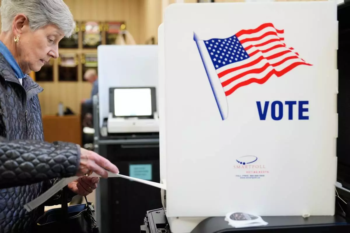 A woman feeds her ballot into a scanning machine at an early voting site in Haverstraw, N.Y., Monday, Oct. 26, 2026. (AP Photo/Seth Wenig)