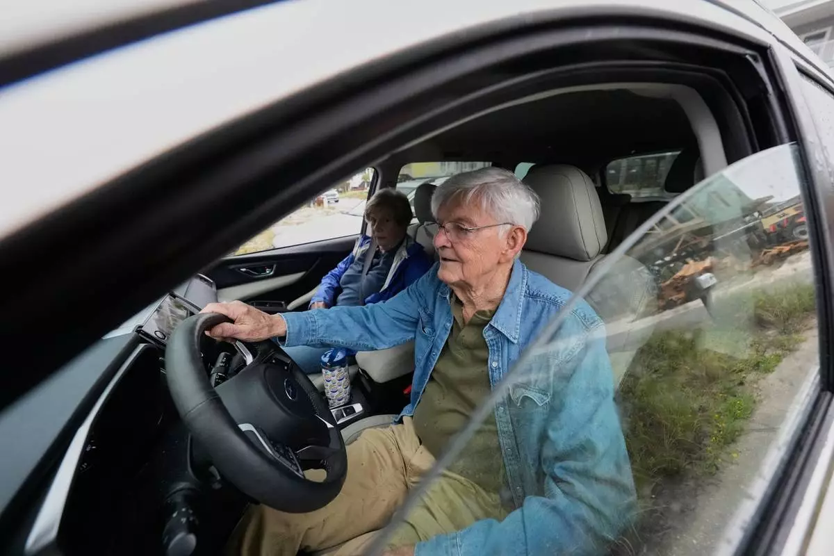 Frank Winn, 84, evacuates with his wife from his home as Hurricane Isaias approaches Pensacola Beach, Fla., Friday, Oct. 9, 2026. (AP Photo/Gerald Herbert)