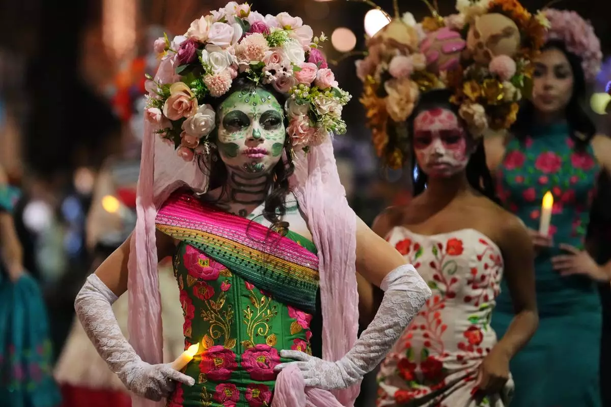 A group of women dressed as Catrinas participate in a parade during a Día de Muertos celebration at Pike Place Market, Friday, Oct. 23, 2026, in Seattle. (AP Photo/Lindsey Wasson)