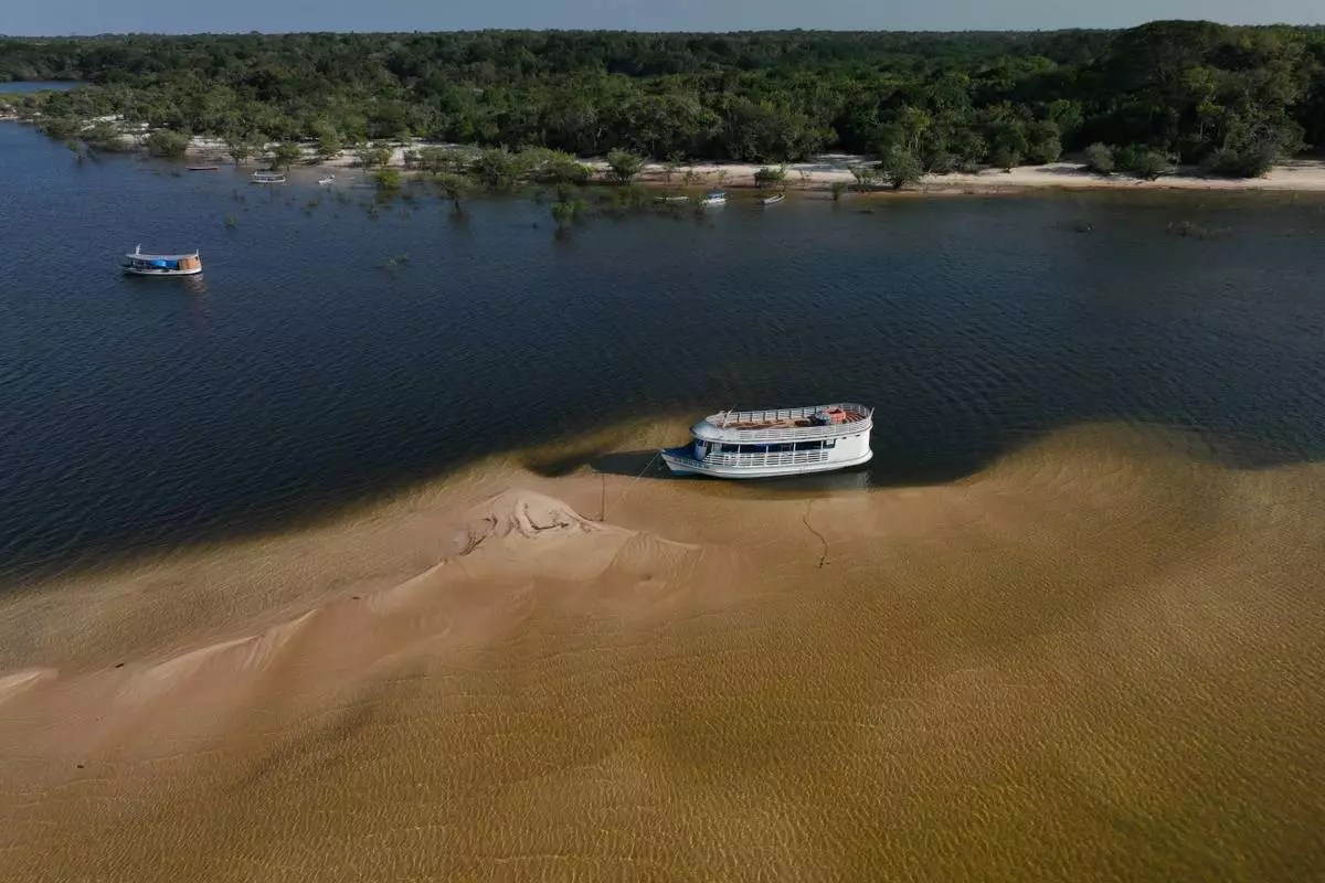 A tourist boat sits idle on sandbanks in the Arapiuns River near the Nova Sociedade community, near Santarem, Para state, Brazil, Thursday, Sept. 3, 2026. (AP Photo/Andre Penner)
