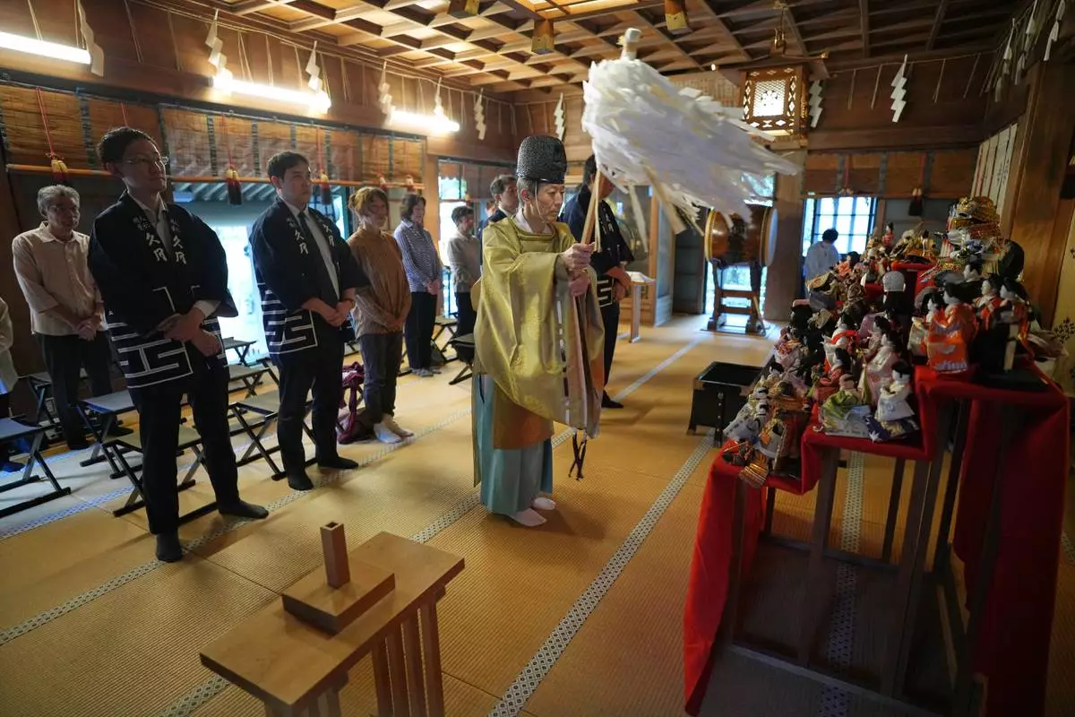 A Shinto priest offers prayers for dolls no longer used by their owners during a traditional doll memorial ceremony at Dairokuten Sakaki Shrine Tuesday, Oct. 13, 2026, in Tokyo. (AP Photo/Eugene Hoshiko)
