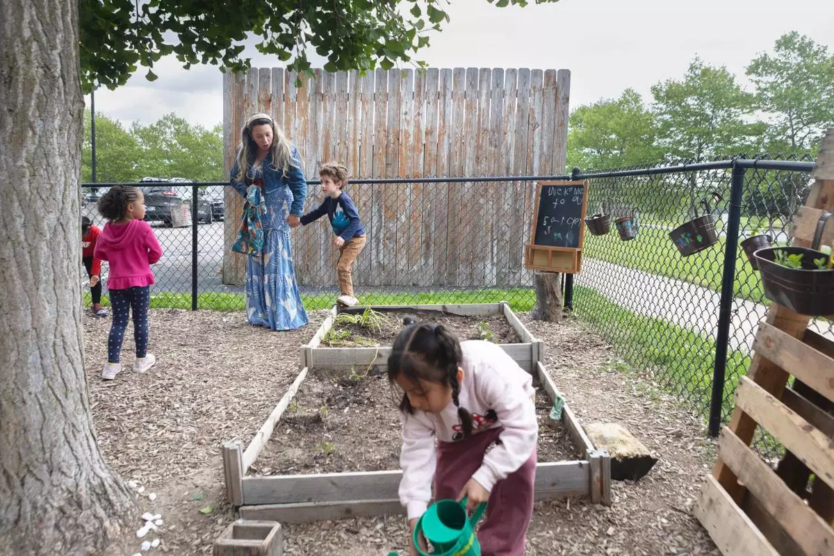 FILE - Diana McGuire leads her 4-year-old son Noah by the hand across the playground at St. Mary's Early Childhood Center in Indianapolis, Ind., May 13, 2026. (AP Photo/Cara Penquite, File)