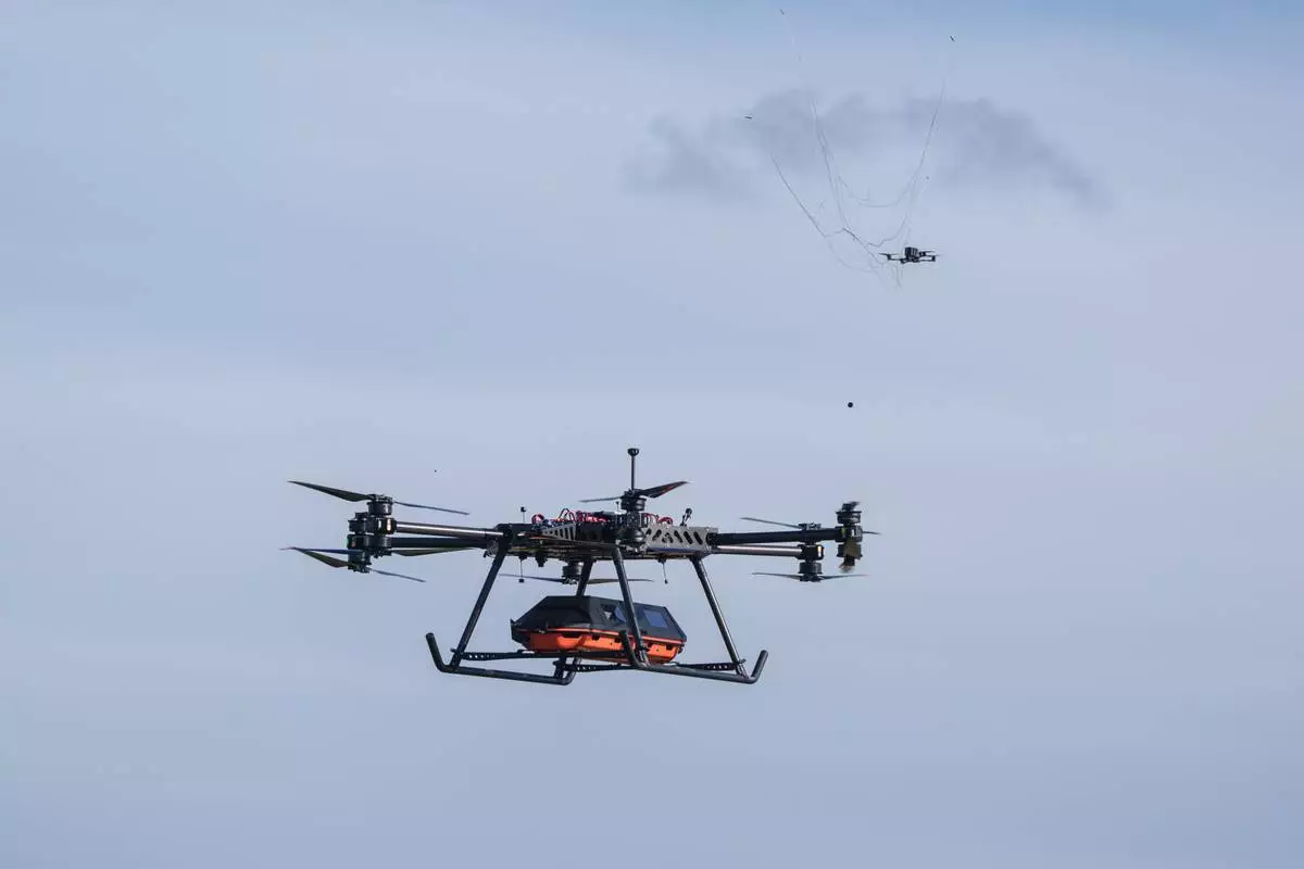The SkyGate drone, made by the SkyFall drone company and equipped with a medical module, deploys a net designed to intercept aerial threats commonly encountered along Ukraine's front line at an undisclosed location in Ukraine, Wednesday, Oct. 14, 2026. (AP Photo/Evgeniy Maloletka)