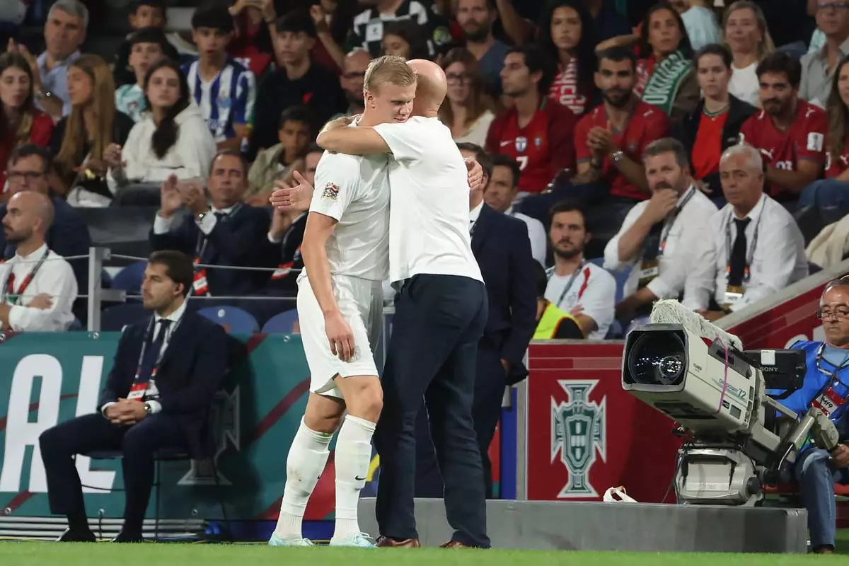 Norway head coach Stale Solbakken embraces Norway's Erling Haaland as he leaves the pitch after being substituted during the Nations League soccer match between Portugal and Norway in Porto, Portugal, Sunday, Oct. 4, 2026. (AP Photo/Luis Vieira)