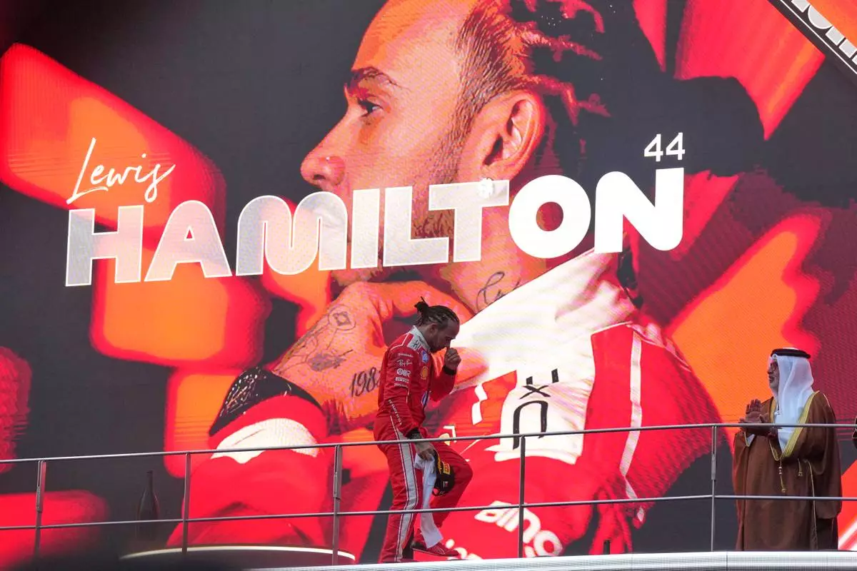 Ferrari driver Lewis Hamilton of Britain steps on the podium after arriving in third place at the Bahrain Grand Prix in Sepang, Malaysia, Sunday, Oct. 4, 2026. (AP Photo/Aijaz Rahi)