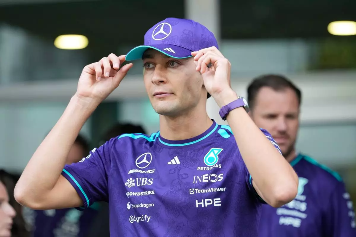 Mercedes driver George Russell of Britain adjust his cap at the paddock ahead of the Singapore Formula One Grand Prix weekend at the Marina Bay Street Circuit in Singapore, Thursday, Oct. 8, 2026. (AP Photo/Vincent Thian)