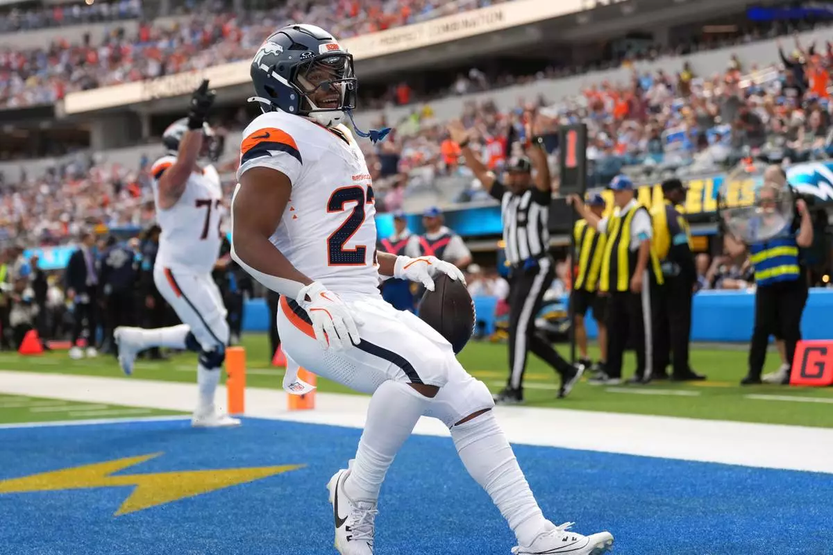 Denver Broncos running back J.K. Dobbins, right, runs in for a touchdown during the first half of an NFL football game against the Los Angeles Chargers, Sunday, Oct. 11, 2026, in Inglewood, Calif. (AP Photo/Scott Strazzante) Correction corrects month to Oct.