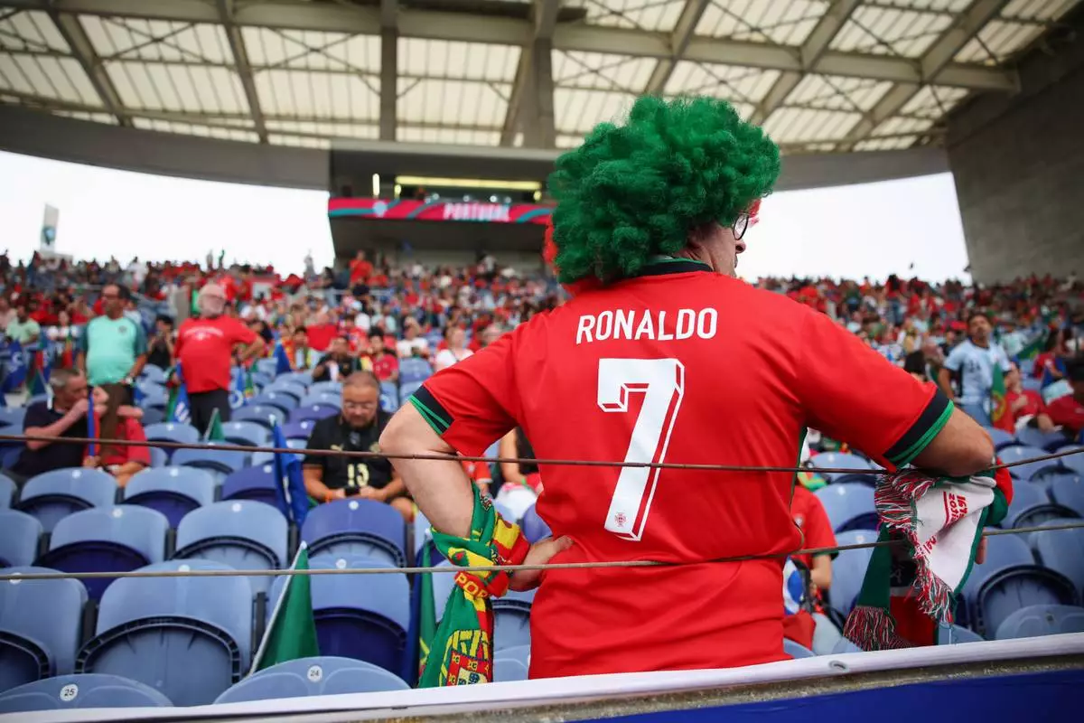 A fan wearing Portugal's Cristiano Ronaldo shirt on the stands waits for the start of the Nations League soccer match between Portugal and Norway in Porto, Portugal, Sunday, Oct. 4, 2026. (AP Photo/Luis Vieira)