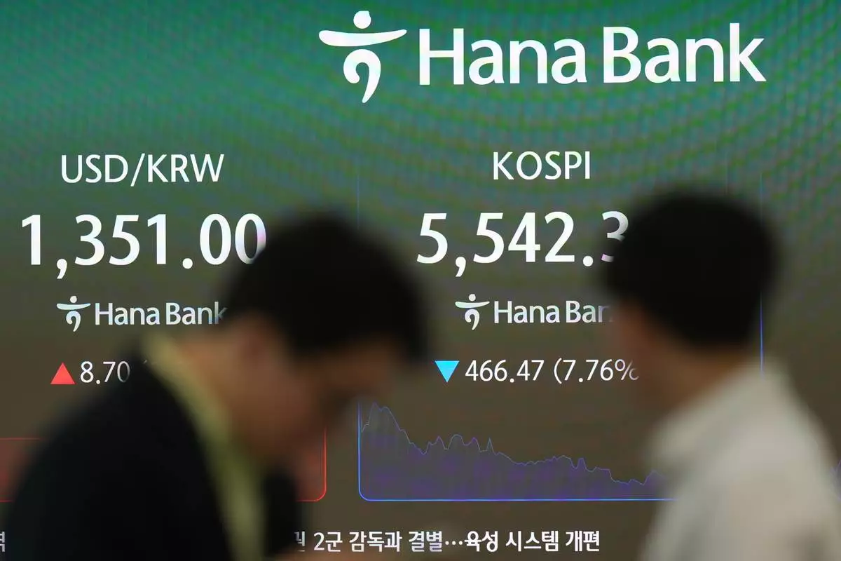 Dealers stand near the screens showing the Korea Composite Stock Price Index (KOSPI), left, and the foreign exchange rate between U.S. dollar and South Korean won at a dealing room of Hana Bank in Seoul, South Korea, Thursday, Oct. 15, 2026. (AP Photo/Lee Jin-man)