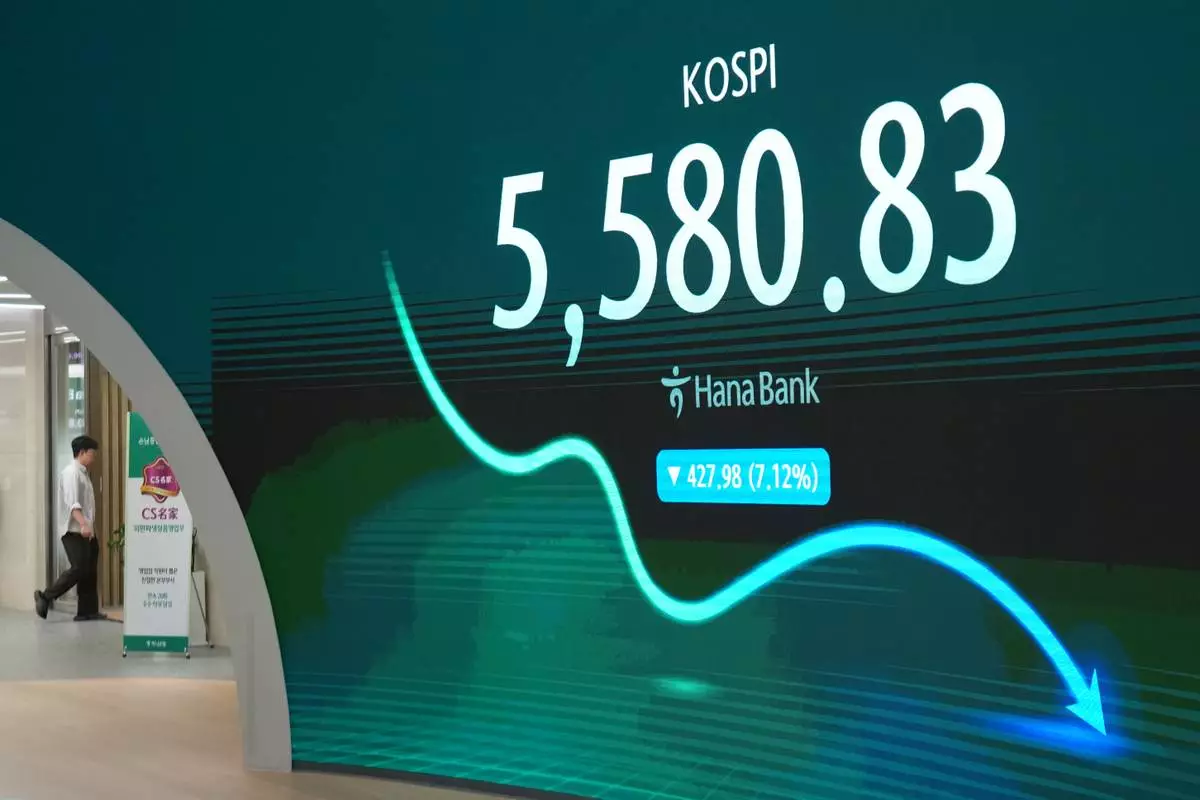 A dealer walks near the screen showing the Korea Composite Stock Price Index (KOSPI) at a dealing room of Hana Bank in Seoul, South Korea, Thursday, Oct. 15, 2026. (AP Photo/Lee Jin-man)