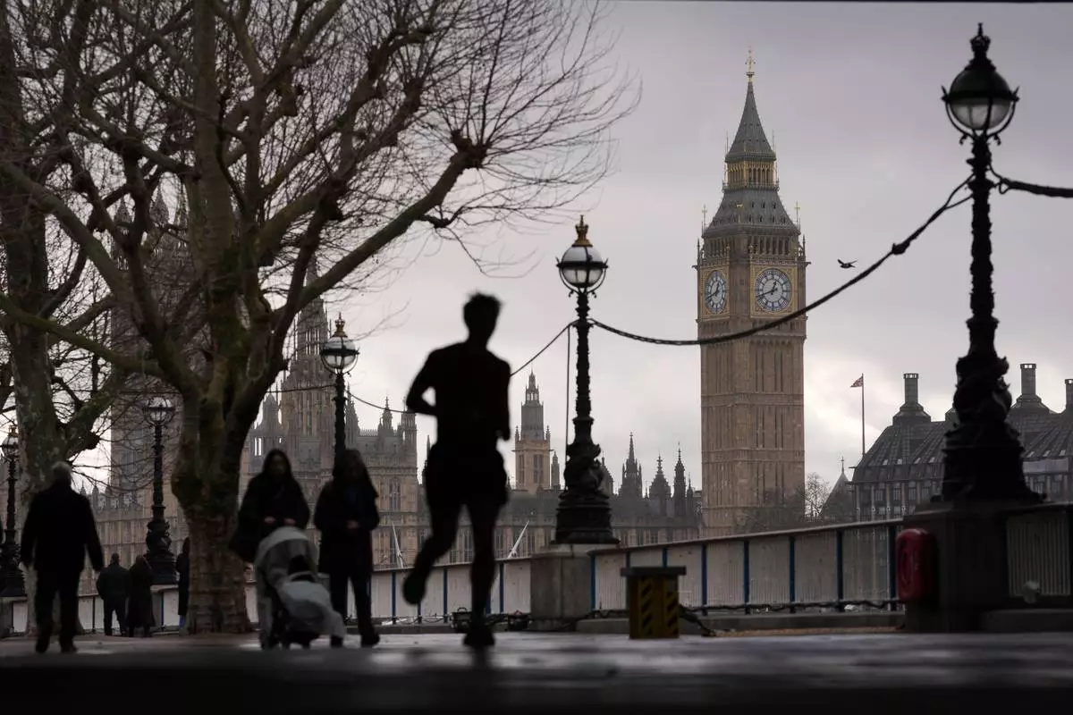 FILE - People walks on the banks of the river Thames besides the Elizabeth Tower, known as Big Ben, and Houses of Parliament in London, Wednesday, Feb. 11, 2026. (AP Photo/Kin Cheung, File)