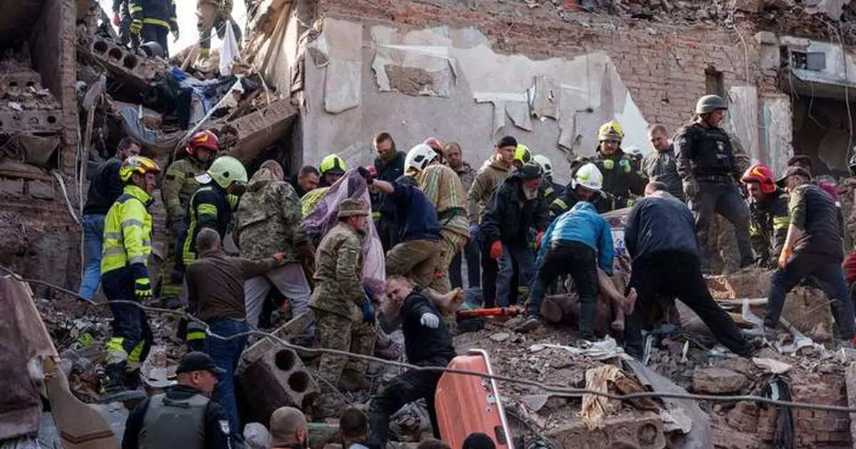 People clear the rubble of a residential building destroyed in a Russian missile strike, in photos