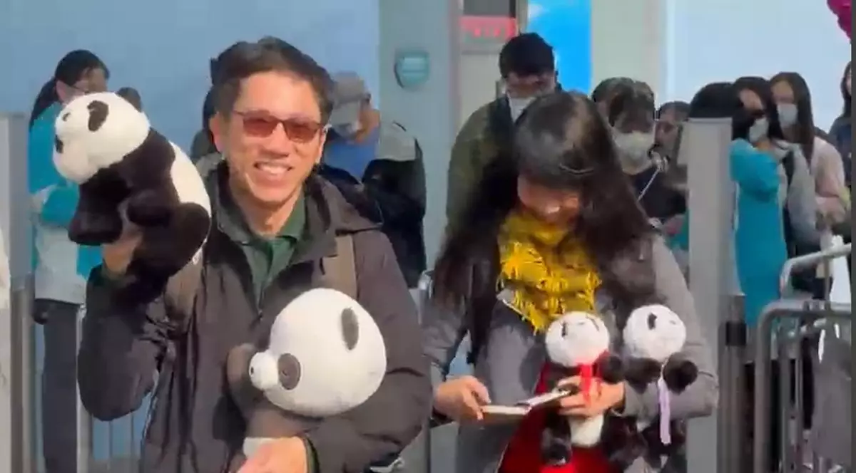 早前受訪的陳先生更大展笑容,揮動手中的熊貓公仔與傳媒打招呼!(巴士的報記者攝)