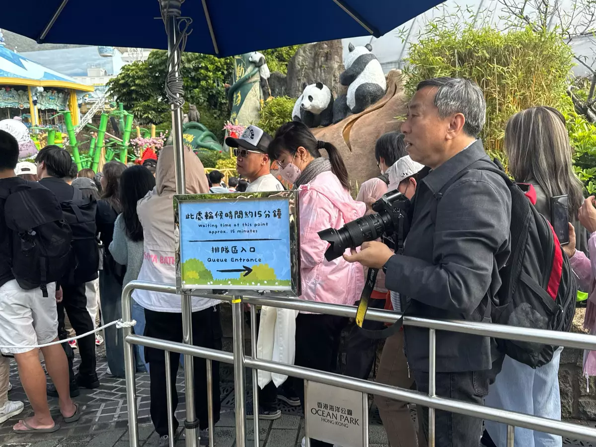 有不少市民帶同專業攝影器材,準備捕捉一對孖寶的得意模樣。(巴士的報記者攝)