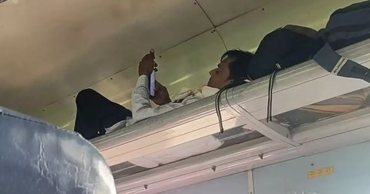 火車頭等位還不夠舒適? 印度乘客躺行李架睇手機自製臥舖