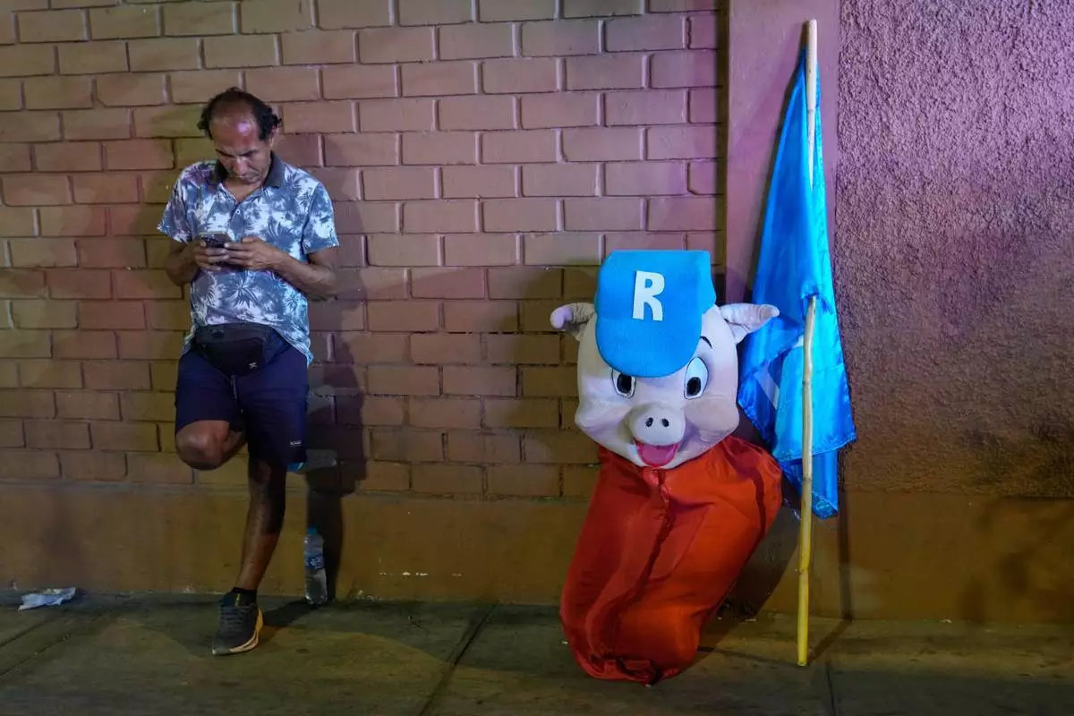 2026年3月31日，秘魯利馬，人民革新黨（Popular Renewal）總統候選人拉斐爾·洛佩斯·阿利亞加（Rafael López Aliaga）的支持者，身穿其綽號「Porky」的服裝，靠牆而立。（美聯社圖片/Martin Mejia） AP圖片