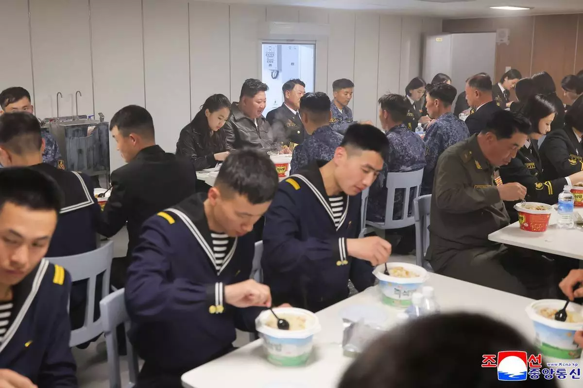 北韓政府於2026年5月8日提供的照片顯示，北韓領袖金正恩（後中）與女兒於2026年5月7日周四，在北韓西海岸的驅逐艦「崔賢」號上與水兵用餐。獨立記者未能獲准採訪北韓政府發布的這張圖片所描述的事件。此圖片內容為來源提供，無法獨立核實。(朝中社/美聯社圖片) AP圖片