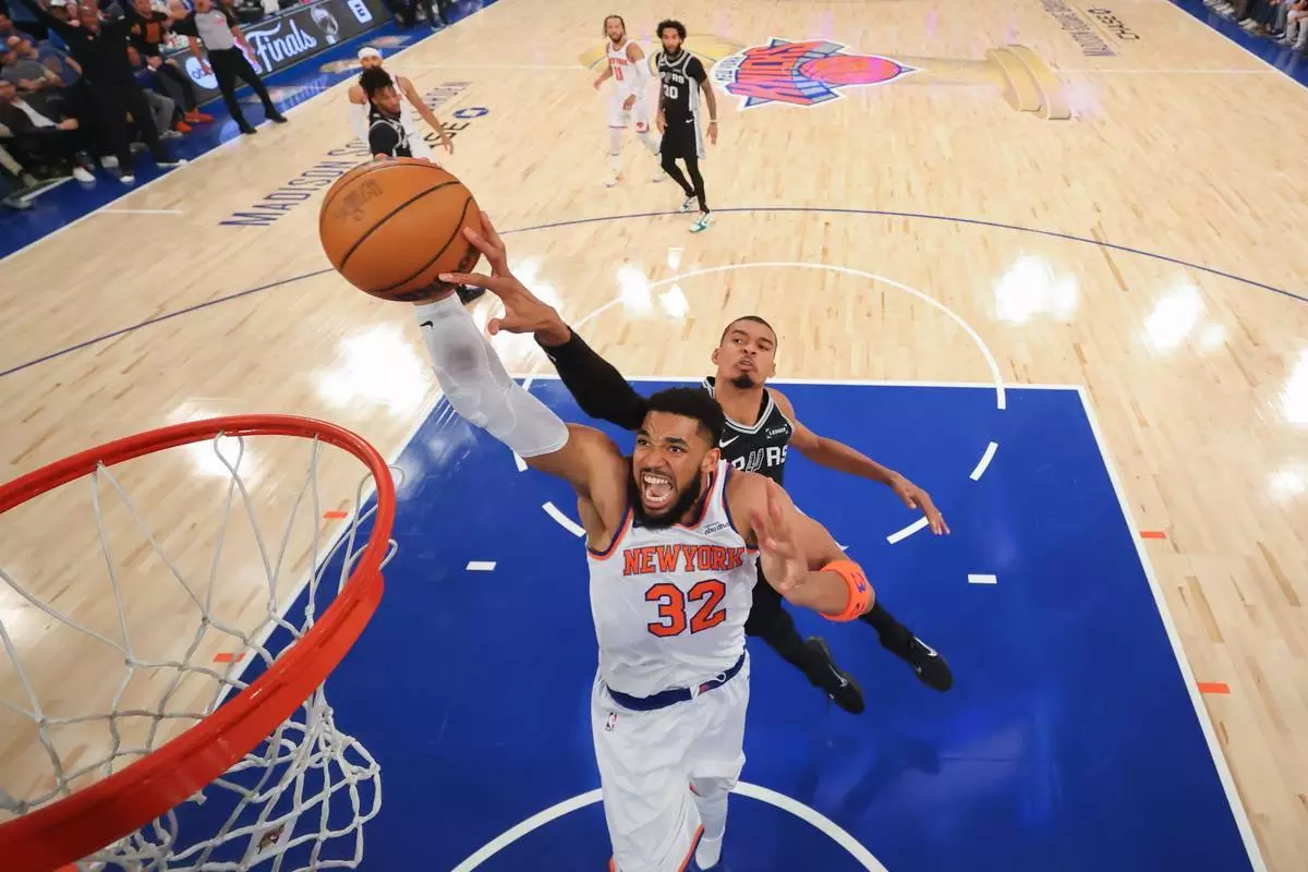2026年6月8日周一，紐約，NBA總決賽第四場籃球賽上半場，紐約人隊中鋒卡爾-安東尼·唐斯（32號）在聖安東尼奧馬刺隊前鋒維克托·文班亞馬面前入樽。(美聯社圖片/Al Bello/Pool Photo) AP圖片