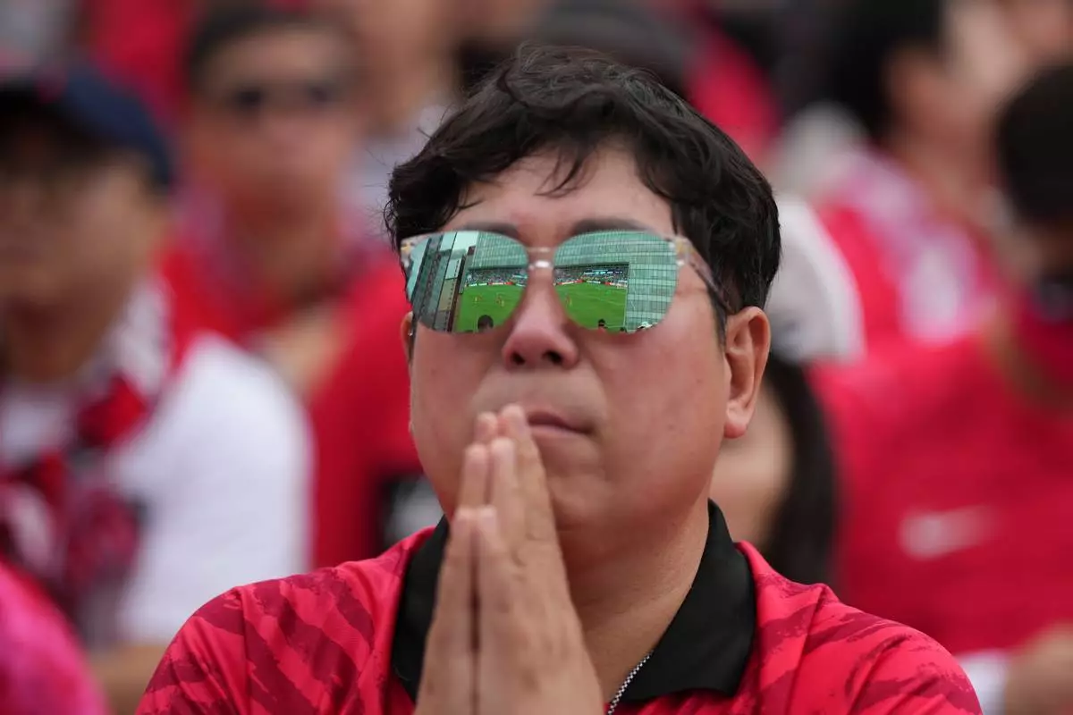 2026年6月25日周四，一名球迷在南韓首爾的公眾觀賽場地，觀看世界盃A組南非對南韓的足球賽直播。(美聯社圖片/Lee Jin-man) AP圖片