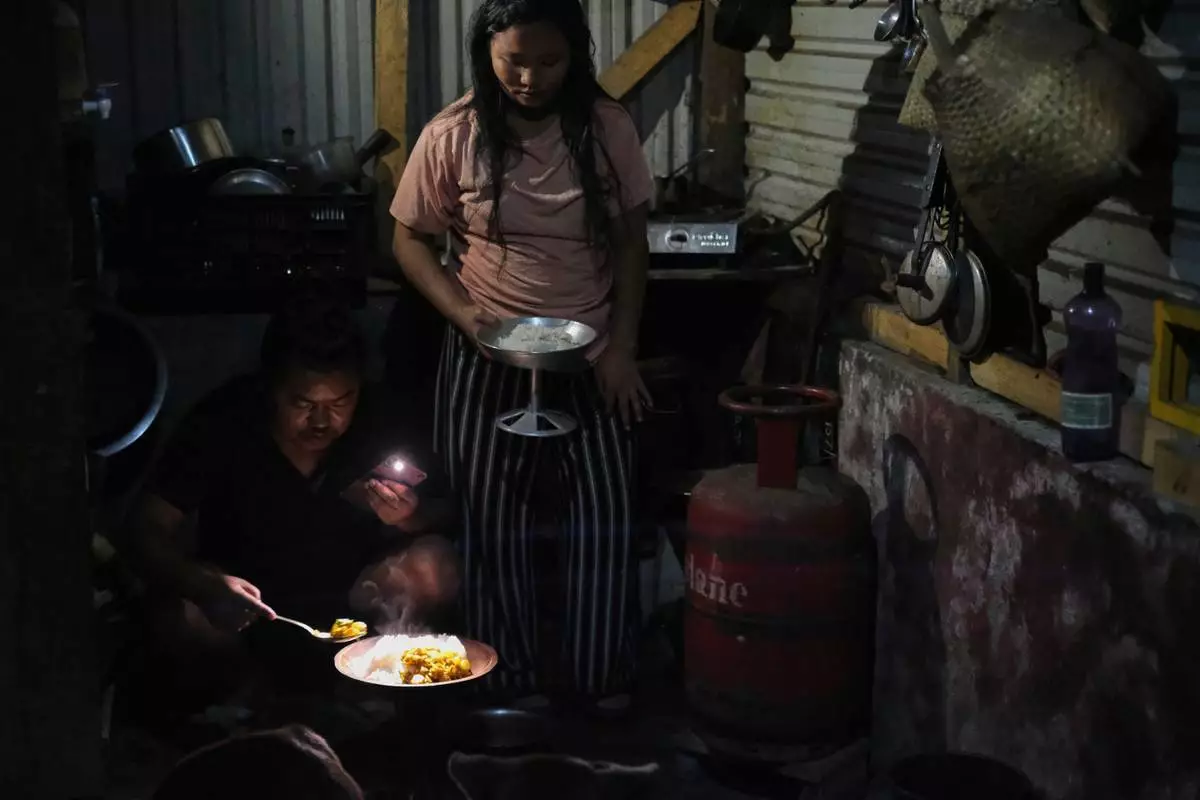 32歲的Tovi Murru與妻子Atoshi Ayemi周一（2026年7月6日），在印度東北部那加蘭邦首府科希馬的廚房內，在一個空的石油氣罐旁上菜。(美聯社圖片/Yirmiyan Arthur) AP圖片