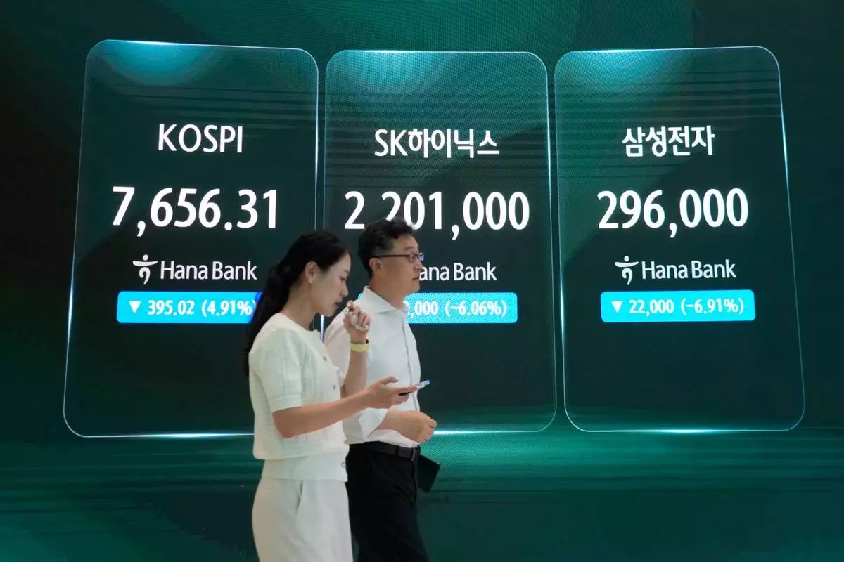 外匯交易員2026年7月7日周二在南韓首爾韓亞銀行總部外匯交易室，經過顯示南韓綜合股價指數（KOSPI）（左）、SK海力士及三星電子股價（右）的屏幕。(美聯社圖片/Ahn Young-joon) AP圖片