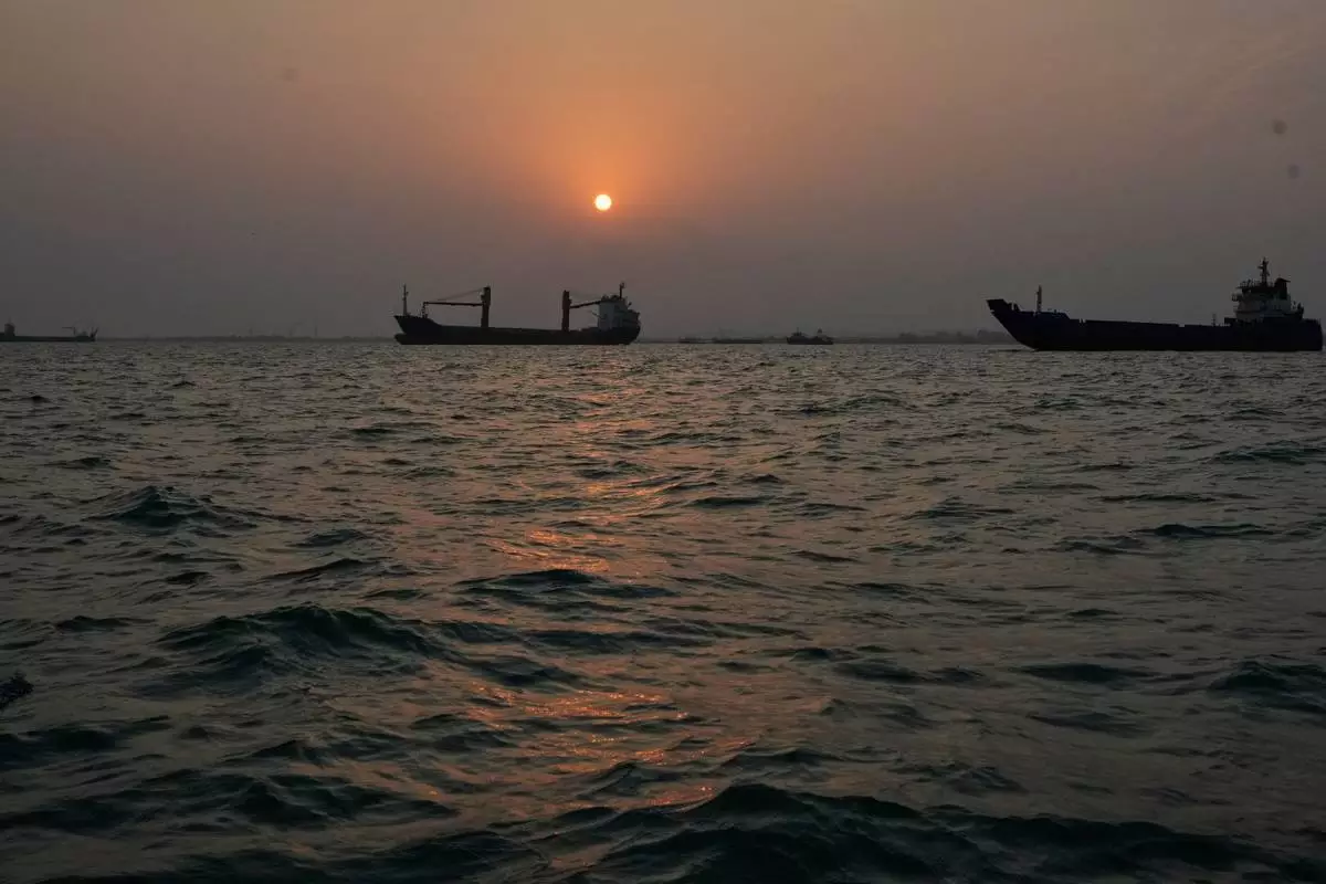 夕陽西下，商船停泊在伊朗班達阿巴斯對開霍爾木茲海峽，城市天際線在背景中。攝於2026年9月6日周日。(美聯社圖片/瓦希德·薩萊米) AP圖片