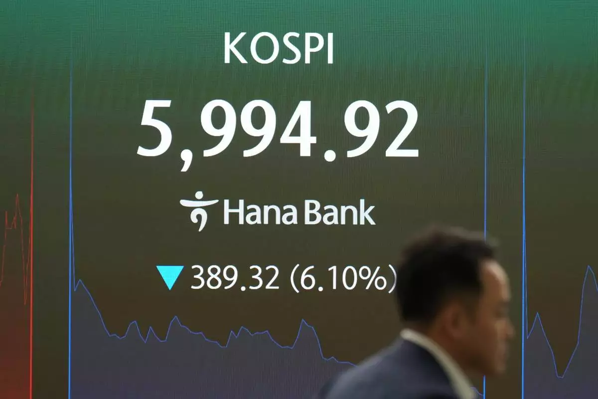 一名交易員走過顯示南韓綜合股價指數（KOSPI）的屏幕，攝於南韓首爾韓亞銀行交易室。周二（2026年10月13日）。(美聯社圖片/Lee Jin-man) AP圖片