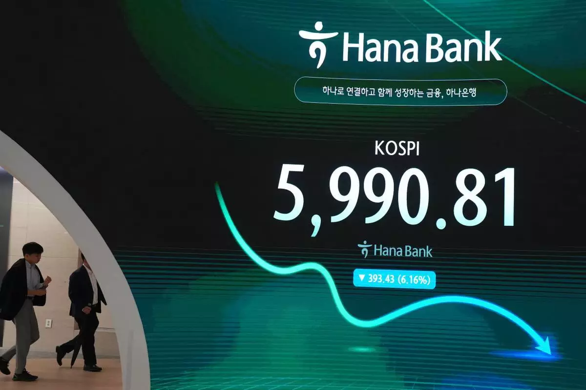 交易員走過顯示南韓綜合股價指數（KOSPI）的屏幕，攝於南韓首爾韓亞銀行交易室。周二（2026年10月13日）。(美聯社圖片/Lee Jin-man) AP圖片
