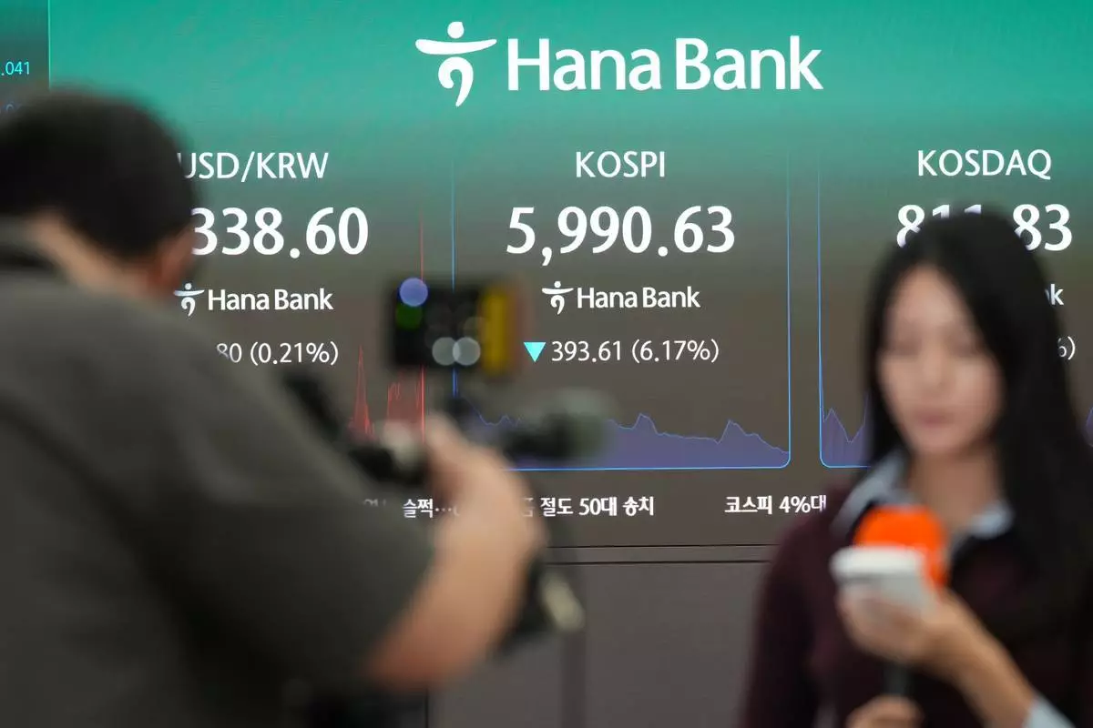 傳媒成員在顯示南韓綜合股價指數（KOSPI）、南韓證券商自動報價系統（KOSDAQ）以及美元兌南韓圜匯率的屏幕附近報道，攝於南韓首爾韓亞銀行交易室。周二（2026年10月13日）。(美聯社圖片/Lee Jin-man) AP圖片