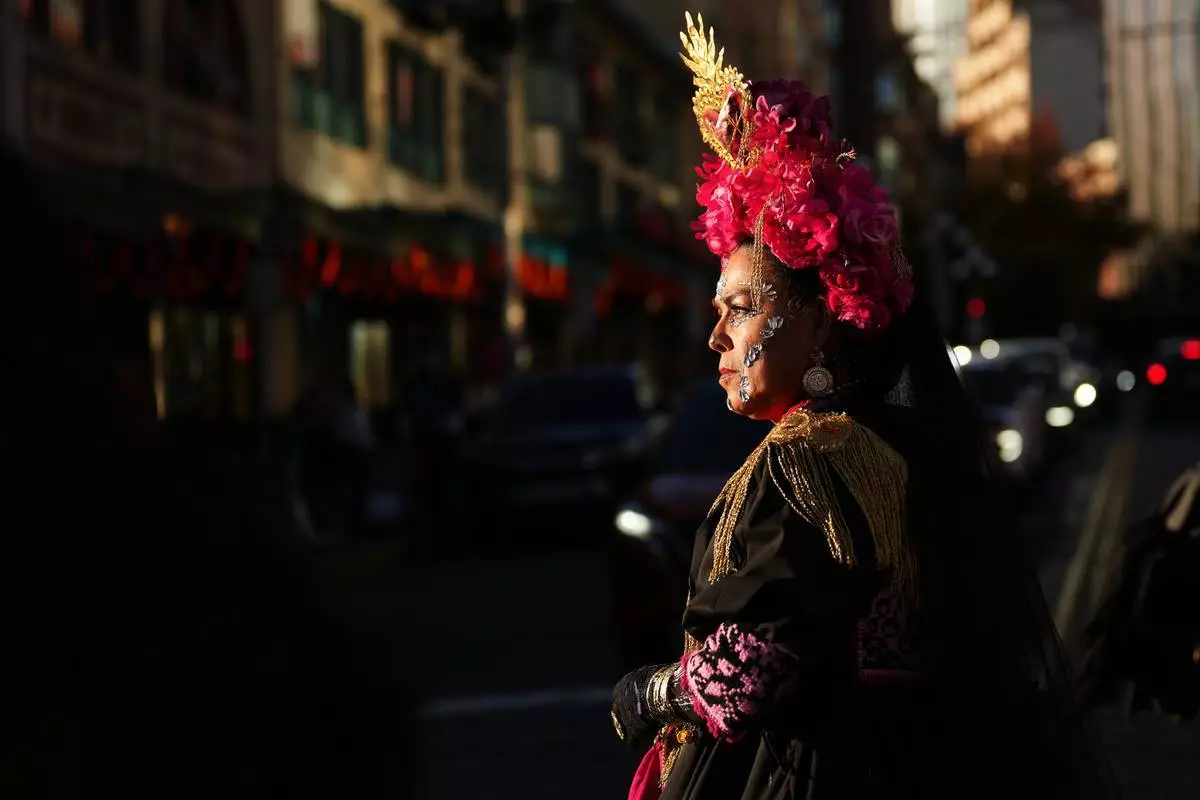 Yolanda Ybarra 周五（2026年10月23日）在西雅圖派克市場的亡靈節慶祝活動期間，走向市場入口。(美聯社圖片/Lindsey Wasson) AP圖片