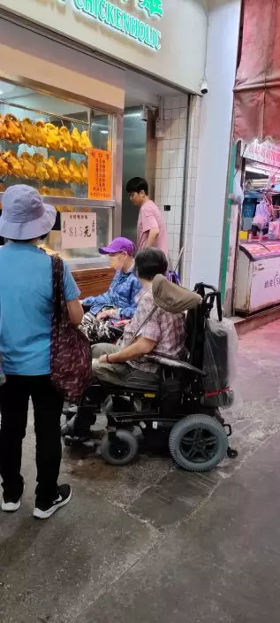 職員待輪椅上長者拿穩外賣飯盒後，才返回店內繼續工作。