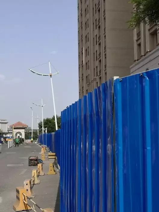 天津碧桂園受損樓棟前被藍色鐵皮板攔住。