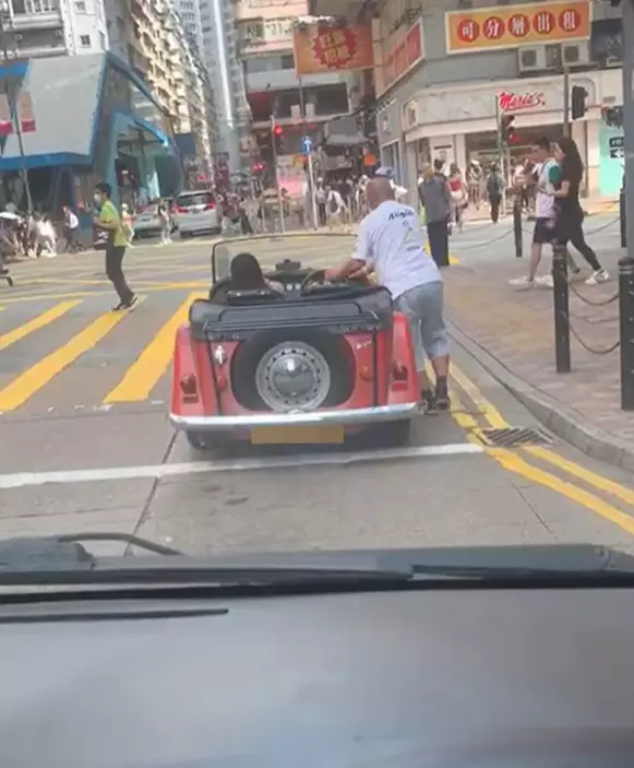 日前有司機分享短片，顯示有開蓬車司機在鬧市中無視交通燈，並以人力推車來避過等紅燈。（Facebook「車cam-L（香港群組）」）