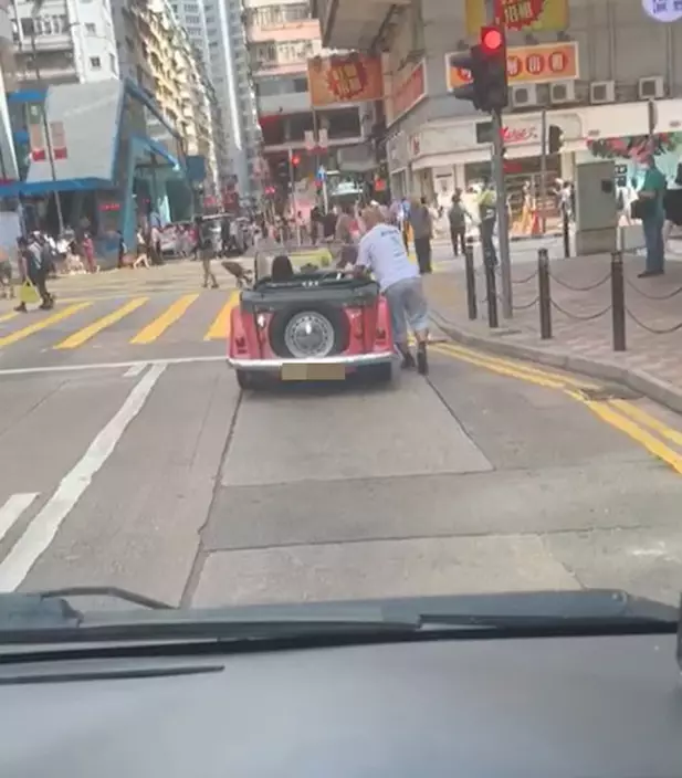 日前有司機分享短片，顯示有開蓬車司機在鬧市中無視交通燈，並以人力推車來避過等紅燈。（Facebook「車cam-L（香港群組）」）