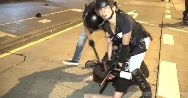 有身穿黑衣人士被警員制服在地上。（施華駿攝）