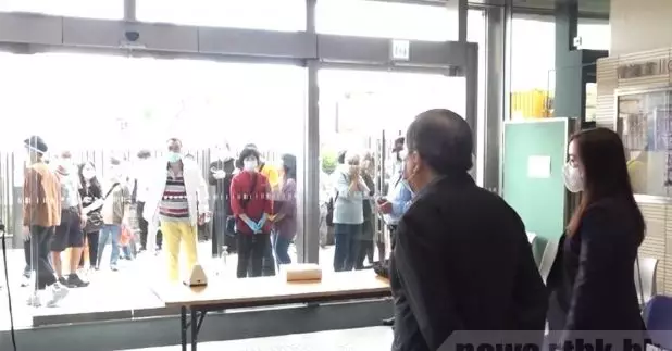 有市民批評排隊時間太長，一度向胡定旭（右二）指罵。（李駿彥攝）