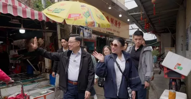 行政長官李家超趁復活節假期到訪大澳,花費數百元購買多款大澳特色食品,為商戶打氣,又與遊客交流。(特首辦片段截圖)