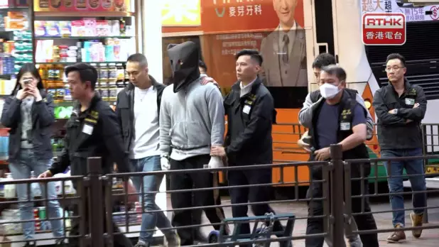 警方今日將被捕人士帶到位於旺角,疑兇曾經在案發前後匿藏和更換衣服的大廈重組案。(孔令輝攝)