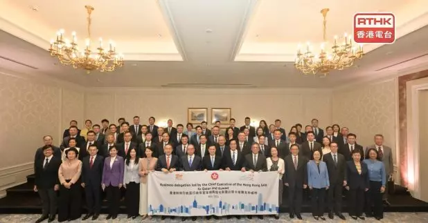 李家超在酒店與隨團的香港和內地代表拍攝大合照。（政府新聞處）