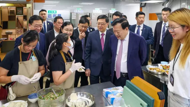 夏寶龍(前排右二)由行政長官李家超(前排右三)和勞工及福利局局長孫玉菡(前排右四)陪同,視察土瓜灣社區客廳設施,了解特區政府「社區客廳試行計劃」推行情況,並與使用者交流。